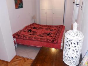 马图利Apartment Milano的一间小卧室,配有一张带红色毯子的床