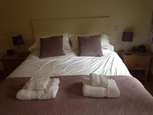 威勒尔曼诺戈登住宿加早餐旅馆的一间卧室配有一张床,上面有两条毛巾