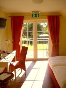 Fockbek兰德豪斯吉奥尼酒店的一间卧室配有一张桌子、一张床、一张桌子和一个窗户。
