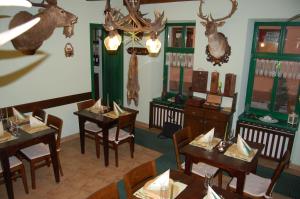 特伦钦温泉镇Penzión Zuzi的墙上设有桌椅和鹿头的餐厅