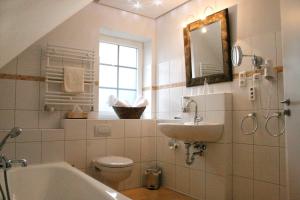 Fockbek兰德豪斯吉奥尼酒店的浴室配有盥洗池、卫生间和镜子。