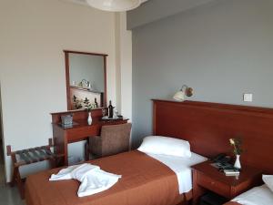 雅典阿波罗酒店的一间卧室配有一张床、一张书桌和一面镜子