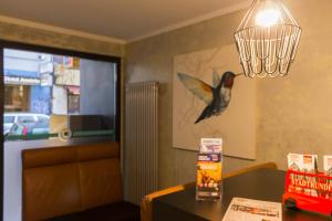 汉堡Hotel West的挂着吊灯的餐厅墙上的鸟儿