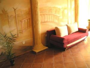 伦蒂堂吉诃德克孜克里旅馆的一张红色沙发,坐在画室里