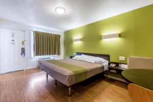 圣拉斐尔圣拉菲尔6号汽车旅馆的卧室配有一张床和一张桌子