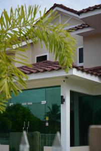 Bandar  Pusat Jengka拜提旅馆的一座带玻璃门和棕榈树的房子