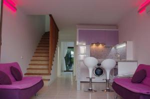 达利安Aydos Suites的客厅配有紫色家具和楼梯