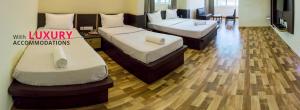 门格洛尔Hotel Bombay Residency--Bombay Lucky Restaurant的配有2张床的酒店客房,铺有木地板