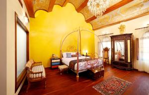 科钦Ginger House Museum Hotel的一间卧室设有一张床和黄色的墙壁