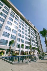 斗六市三好国际酒店的一座白色的大建筑,前面有棕榈树