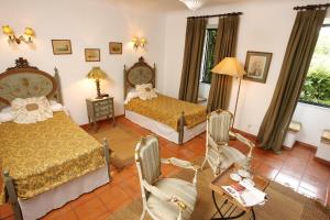 阿尔科谢蒂奎塔达斯富酒店的一间卧室配有两张床和一张桌子及椅子