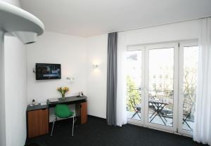科隆切尔西酒店的客房设有带绿椅的书桌和阳台。