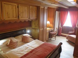 布勒伊-切尔维尼亚Chambres Mont Cervin的一间卧室配有一张床、一张桌子和一把椅子