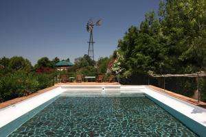 阿尔科谢蒂奎塔达斯富酒店的后院的游泳池,配有桌椅