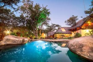 侯斯普瑞特Pezulu Tree House Lodge的房屋前有游泳池的房子