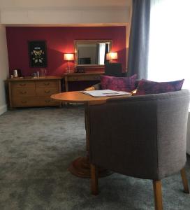 切斯特驿站酒店的客厅配有桌子和椅子