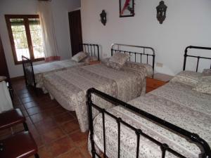丰特-德彼德拉Alojamientos rurales La Torca的一间卧室设有三张床和窗户。