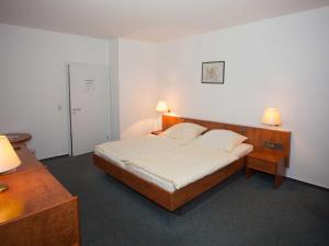 明登祖尔施特默珀斯特酒店的一间卧室配有一张大床和两盏灯。