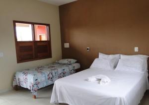伊塔乌纳斯Pousada Flores的酒店客房设有两张床和窗户。