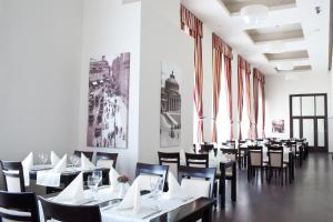 布加勒斯特欧洲酒店皇家布加勒斯特的用餐室设有桌椅和窗户。