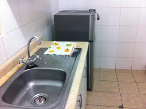 利马Departamento Miraflores的厨房柜台设有水槽和冰箱