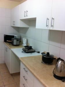 利马Departamento Miraflores的厨房配有白色橱柜和柜台上的锅碗瓢盆