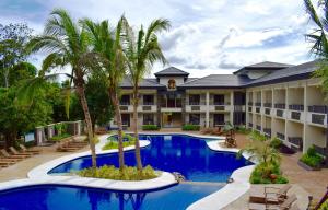 科隆科伦韦斯敦泻湖MO2酒店的一个带游泳池和棕榈树的度假村