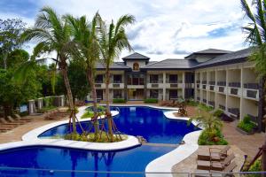 科隆科伦韦斯敦泻湖MO2酒店的一个带大型游泳池和棕榈树的度假村