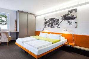 圣彼得奥尔丁Hotel Windschur的一间卧室配有一张带橙色床头板的床