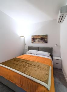 米兰蓝天公寓的一间卧室配有一张带橙色床罩的床