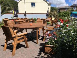 波特里斯Portreath Arms的鲜花庭院里的木桌和椅子