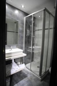 索里亚杜日斯寺酒店的一间带玻璃淋浴和水槽的浴室