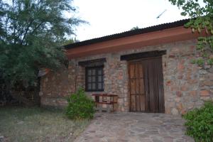鲁伊德拉La Cabaña de Piedra的一座石屋,木门和一棵树