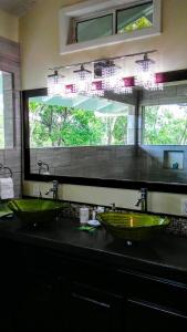 乌蒂拉Serenity Beach Cottages的浴室设有两个绿色水槽和窗户。