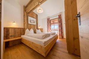 迈尔霍芬Ahornlodge的卧室配有一张床铺,位于带木墙的房间内