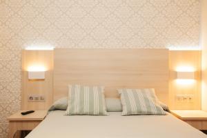 巴塞罗那费南多旅馆的一间卧室配有带2个枕头的床