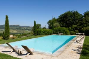 蒙特普齐亚诺Podere Poggio al sole的花园内的游泳池,带两把草坪椅