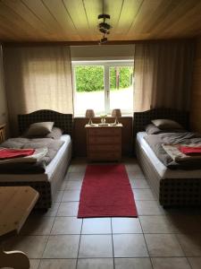 施卢赫湖Ferienhaus Haber的红色地毯的客房内的两张床