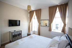 卡斯卡伊斯套房住宿加早餐旅馆的一间卧室设有两张床、一台电视和窗户。