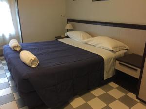 米兰艾娃酒店的一间卧室配有一张大床和毛巾