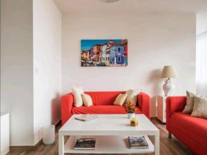 多列毛利诺斯普拉亚马尔r公寓的客厅配有红色的沙发和桌子