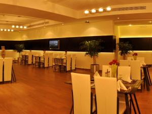 利雅德Nelover Qurtubah Hotel的宴会厅配有白色的桌椅和电视