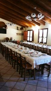 阿尔布斯Agriturismo SaTanca的大型用餐室配有长桌和椅子