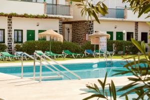 多列毛利诺斯Hotel Los Jazmines的一个带椅子和遮阳伞的游泳池