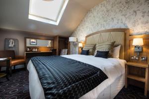 亨廷登桑福德豪斯威瑟斯本酒店的一间卧室,卧室内配有一张大床