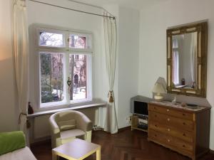 柏林利连塔伊思洛辰公寓的客厅配有椅子、梳妆台和窗户