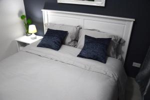 马尼拉Jazz Makati Luxury Apartment的一张带两个蓝色枕头的白色床