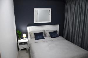 马尼拉Jazz Makati Luxury Apartment的一间卧室配有一张带蓝色墙壁和镜子的床