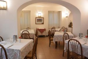 热那亚潘森酒店的餐厅配有桌椅和白色的桌布