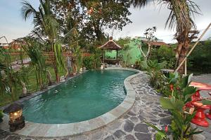 登巴萨RedDoorz near Stadion Kompyang Sujana Bali的花园内的游泳池,带凉亭